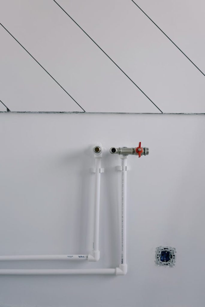 White wall with minimalist plumbing pipes and diagonal lines